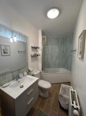 Bathroom features a sink, toilet, and glass-enclosed shower area.