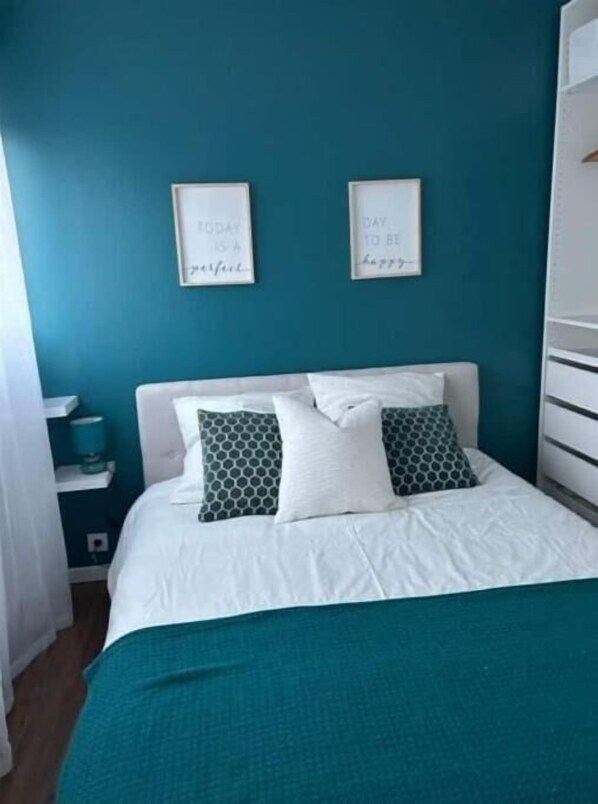 Relax in a serene space with a comfortable bed, framed quotes, and a stylish wardrobe.