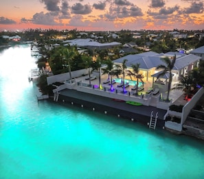Un complexe hôtelier doté d’une piscine, de chaises longues et offrant une vue sur l’eau.