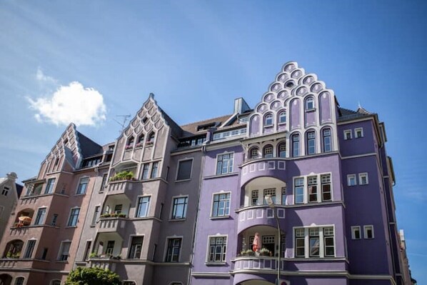 A multi-story building with a distinctive architectural style, featuring ornate balconies and a mix of curved and angular designs.
