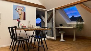 Ein Essbereich mit einem Holztisch, schwarzen Stühlen und einem Gemälde an der Wand.