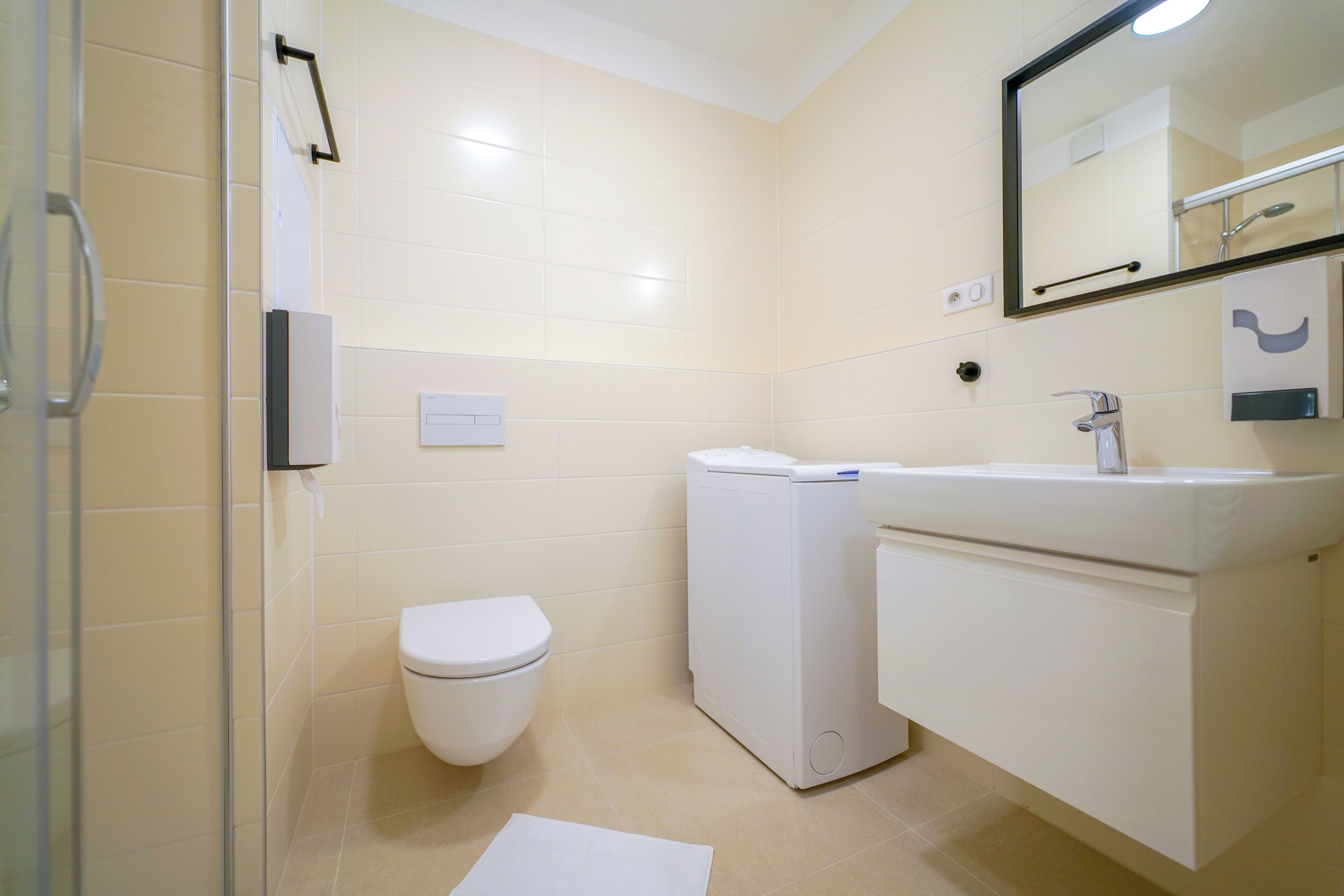 Ein Badezimmer mit Toilette, Waschmaschine und Waschbecken.