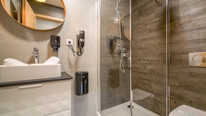 A modern bathroom with a glass-enclosed shower, a white sink, and a toilet. - Svarog Unique Apartment by CHORS (Bratislava)