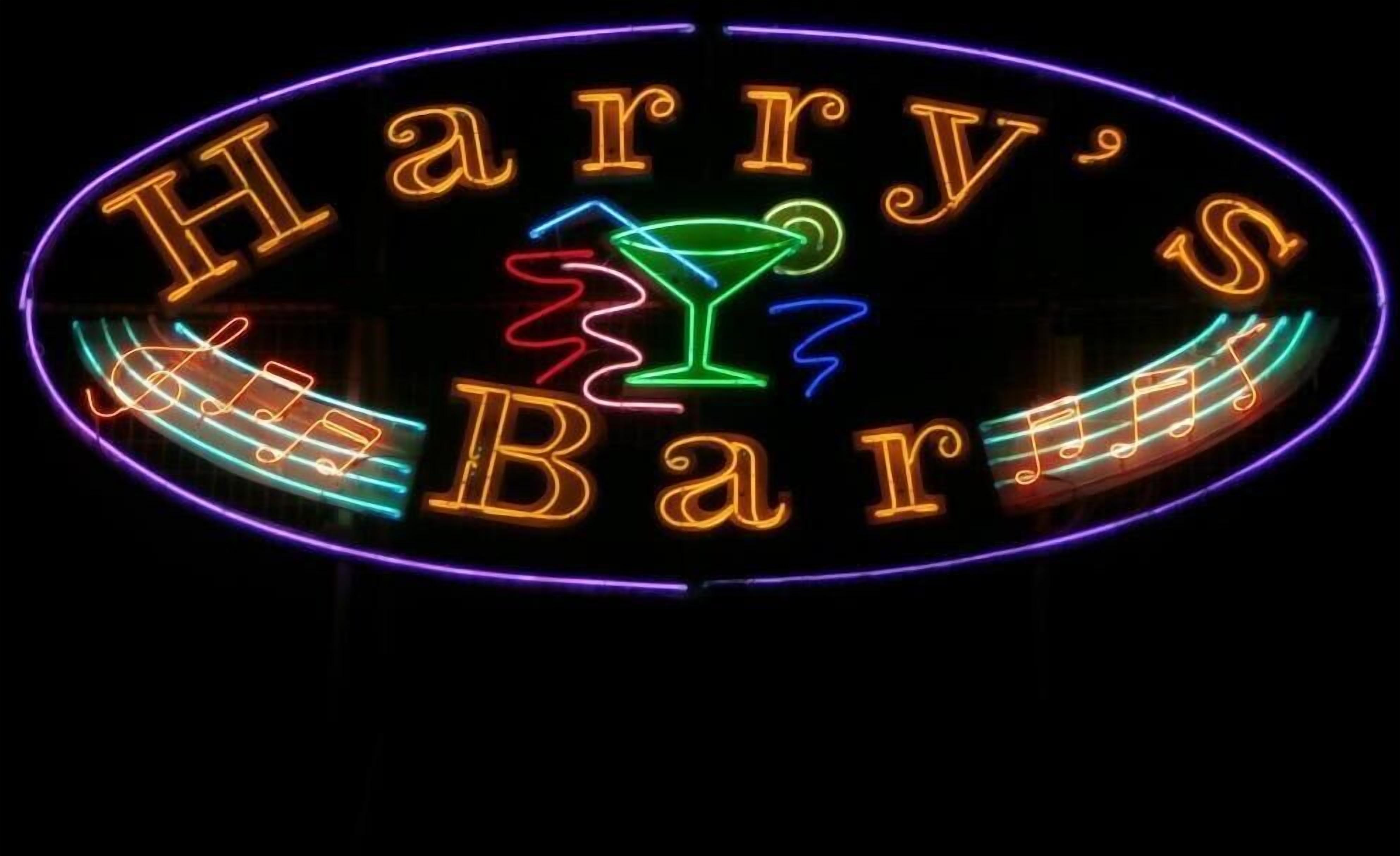 A neon sign for Harry's Bar with a martini glass and musical notes.