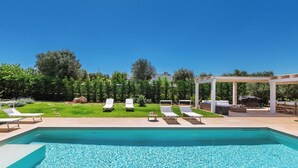 A rectangular swimming pool with clear blue water, surrounded by white lounge chairs and a covered seating area. - 3646 Casal 800 by Perle di Puglia (Ostuni)