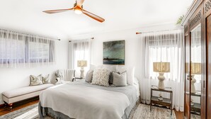A spacious bedroom with a large bed, a ceiling fan, and a bench. - Mountain Retreat w/ Deck: Near Blue Ridge Parkway (Blowing Rock)