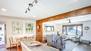 A spacious living area with a wooden ceiling, a dining table with chairs, a sofa, and a large window providing natural light. - Mountain Retreat w/ Deck: Near Blue Ridge Parkway (Blowing Rock)
