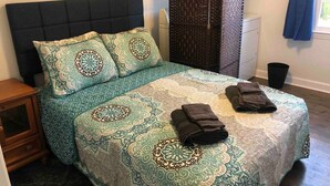 A neatly made bed with patterned bedding and two folded towels on the bed. - 3br/2ba APT, sleeps 7, comfortable and spacious for whole family to spread out (Hickory)