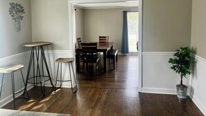 A dining area with a wooden table and chairs, a ceiling fan, and a potted plant. - 3br/2ba APT, sleeps 7, comfortable and spacious for whole family to spread out (Hickory)