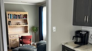 A modern kitchen with dark cabinets, a countertop, and a coffee maker. - 3br/2ba APT, sleeps 7, comfortable and spacious for whole family to spread out (Hickory)