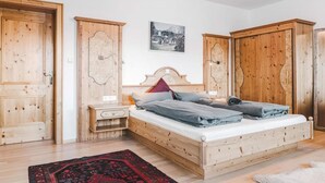 Ein Schlafzimmer mit einem hölzernen Bett, Nachttischen und Kleiderschränken.