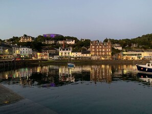 A waterfront view with buildings, a boat, and reflections on the water. - Red Squirrel Pod with Hot Tub - perfect for relaxing in countryside near Oban (Oban)