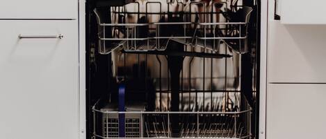 An open dishwasher with multiple racks and a blue water filter.