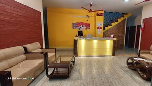 A hotel lobby with a reception desk, sofas, a coffee table, and a staircase. - Hotel Citizen (Khulna)