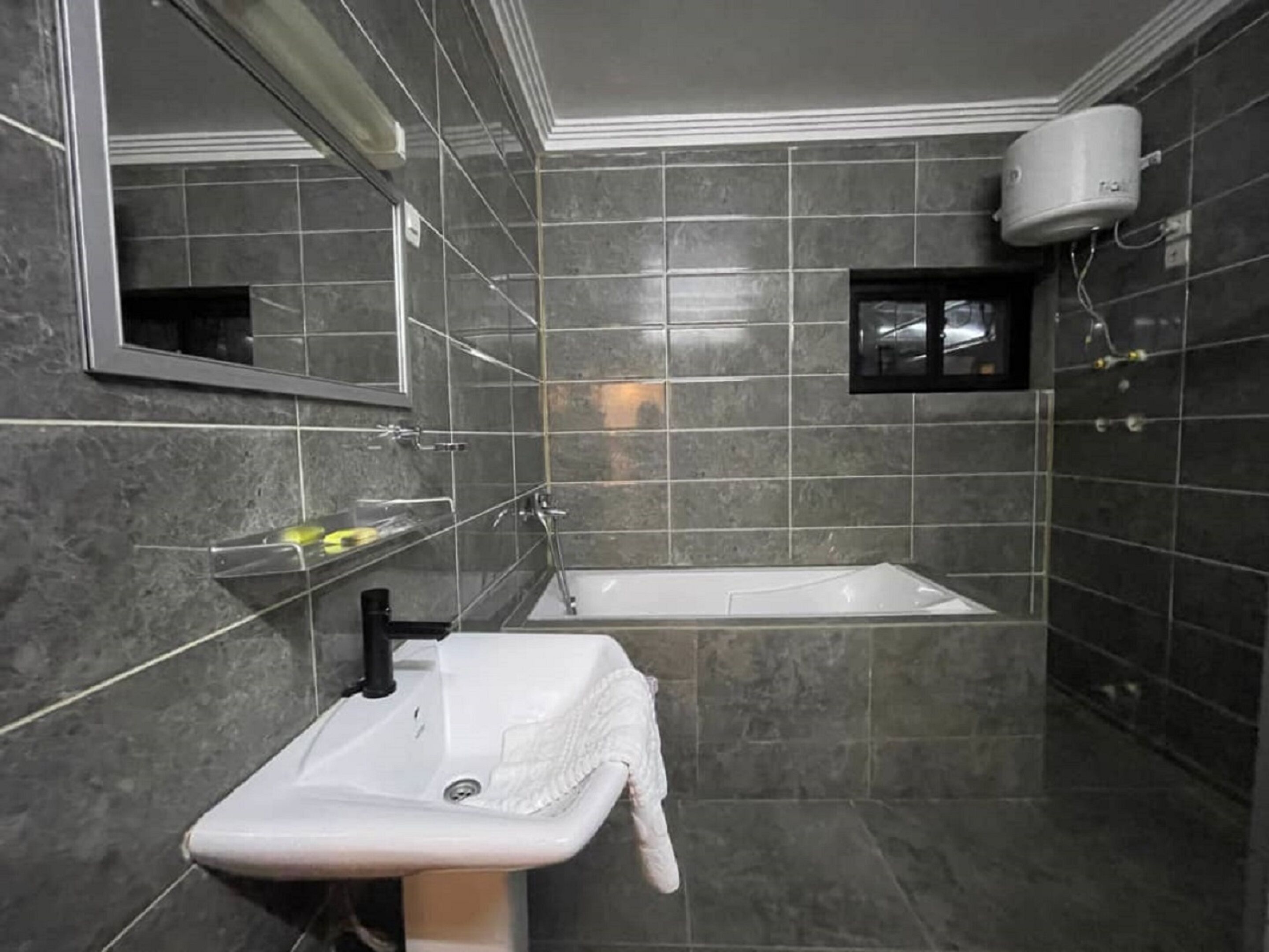 Un baño con lavamanos blanco, bañera y espejo.