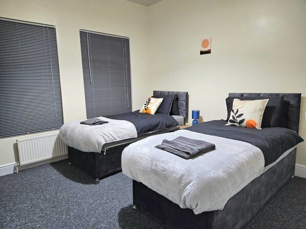 A double room with two beds, each with a headboard, a small table, and a lamp. - Spacious,luxury, Near City Center, Free Parking (Coventry)