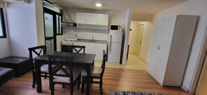 Cozy living space with a kitchenette, dining table, and sofa.