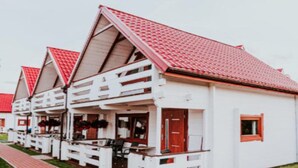 Una hilera de edificios blancos con tejados rojos y balcones de madera.