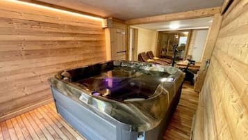 Un intérieur en bois avec un jacuzzi et un espace salon.