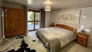 Une chambre à coucher avec un grand lit, une armoire en bois et un tapis en peau de vache.