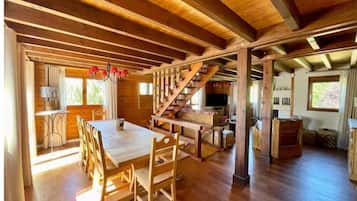 Un intérieur spacieux en bois, comprenant un coin repas, un escalier et une cuisine.
