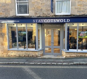 A holiday cottage with a stone facade, large windows, and a sign reading "STAY COTSWOLD Holiday Cottages". - 3 minutes from the famous stone bridges of Bourton on the Water  - Callow Cottage (Bourton-on-the-Water)