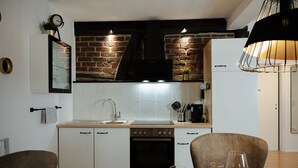 Een moderne keuken met witte kasten, een roestvrijstalen spoelbak en een bakstenen muur.