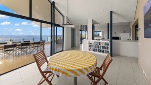Un comedor moderno con una mesa redonda, sillas y vistas al mar.