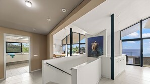 Una cocina moderna con una isla grande, un comedor y vista al mar.