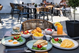 A breakfast setting with various dishes including eggs, toast, and fruit.