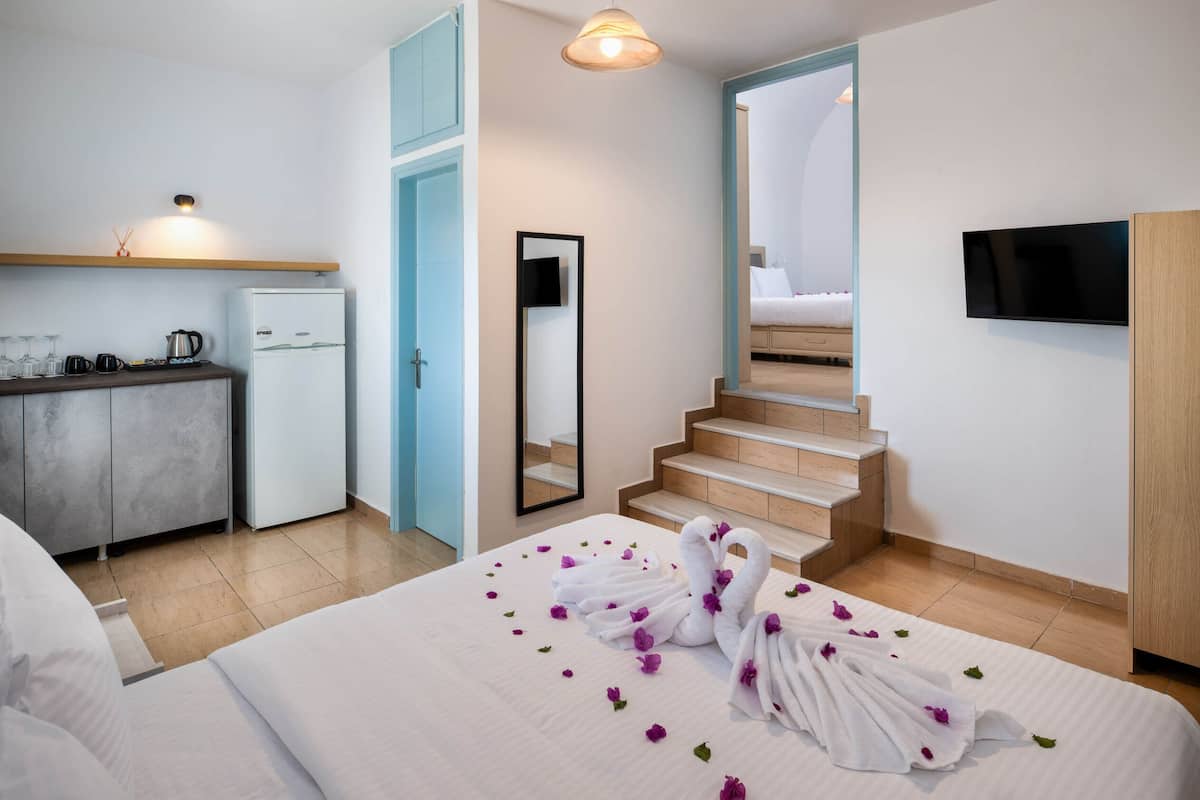 Een hotelkamer met een bed, een badkamer, een keuken en een televisie.