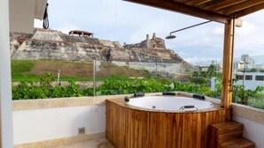 A hot tub on a rooftop with a view of a historical site in the background. - Casa Azul 1 💙 El Espinal (Cartagena de Indias)