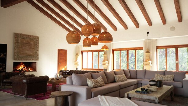 A spacious living room with a large sectional sofa, a fireplace, and large windows. - Mountains of Hope  (Rionegro)