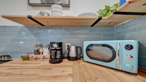 A kitchen with a coffee bar, a microwave, and a coffee maker. - Bali style 1/1 beach villa (Deerfield Beach)