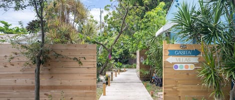 Un sentier en bois mène à un bâtiment portant l’inscription « CASITA VILLAS ».