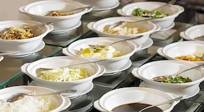 A buffet table with various dishes in white bowls, each with a spoon. - Grand Rohan Jogja (Banguntapan)