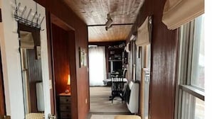 A narrow hallway with wooden walls, a bench, and a radiator. - Barnaminium Upstairs Loft (Pickens)