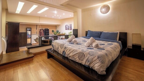 A modern bedroom with a large bed, a desk, and a wardrobe. - Vintage Vibrant Space ! (Cairo)