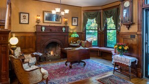 Une chambre de style traditionnel, dotée d’une cheminée, de meubles en bois et offrant une vue par le biais d’une grande fenêtre.
