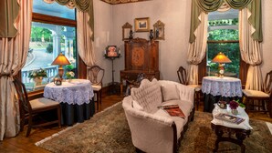 Une pièce de style traditionnel, comprenant un canapé, deux fauteuils, une table et un buffet.