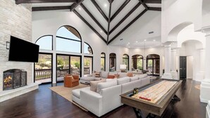 A spacious living room with a large sectional sofa, a wooden coffee table, and a fireplace. - Scottsdale Diamond Mtn Oasis+Waterslide+Pickleball (Scottsdale)