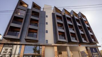 Un edificio moderno de hotel con varios pisos, ventanas amplias y un llamativo letrero que dice 'LUEL HOTEL'.