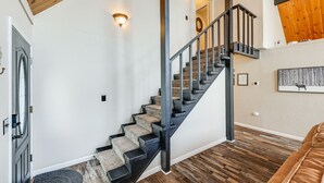 A staircase with a wooden finish, a black railing, and a carpeted landing. - Serene Cabin Retreat Between Murphys & Arnold (Murphys)