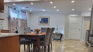 Un coin repas avec une table et des chaises, une lampe et un tableau encadré au mur.