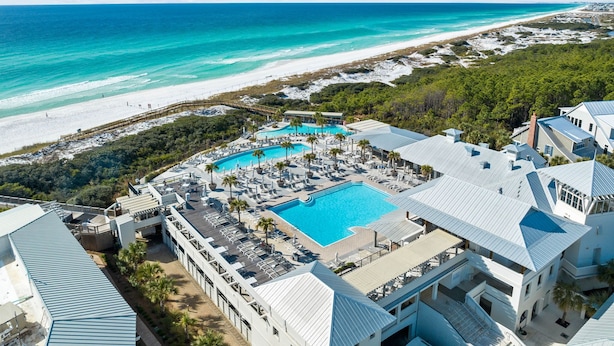 A resort with a large pool, beach access, and a view of the ocean.