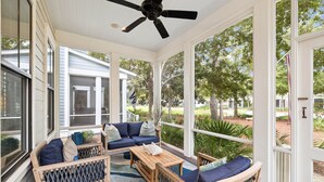 A covered porch with a ceiling fan, a sofa set, and a coffee table.