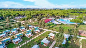 Et boligområde med flere små huse, en swimmingpool og en stor grøn park.
