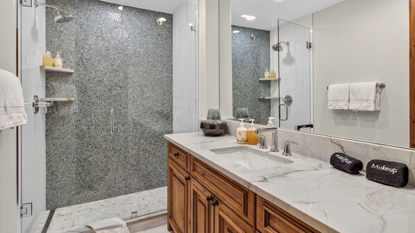 A modern bathroom with a shower, a sink, and a vanity.