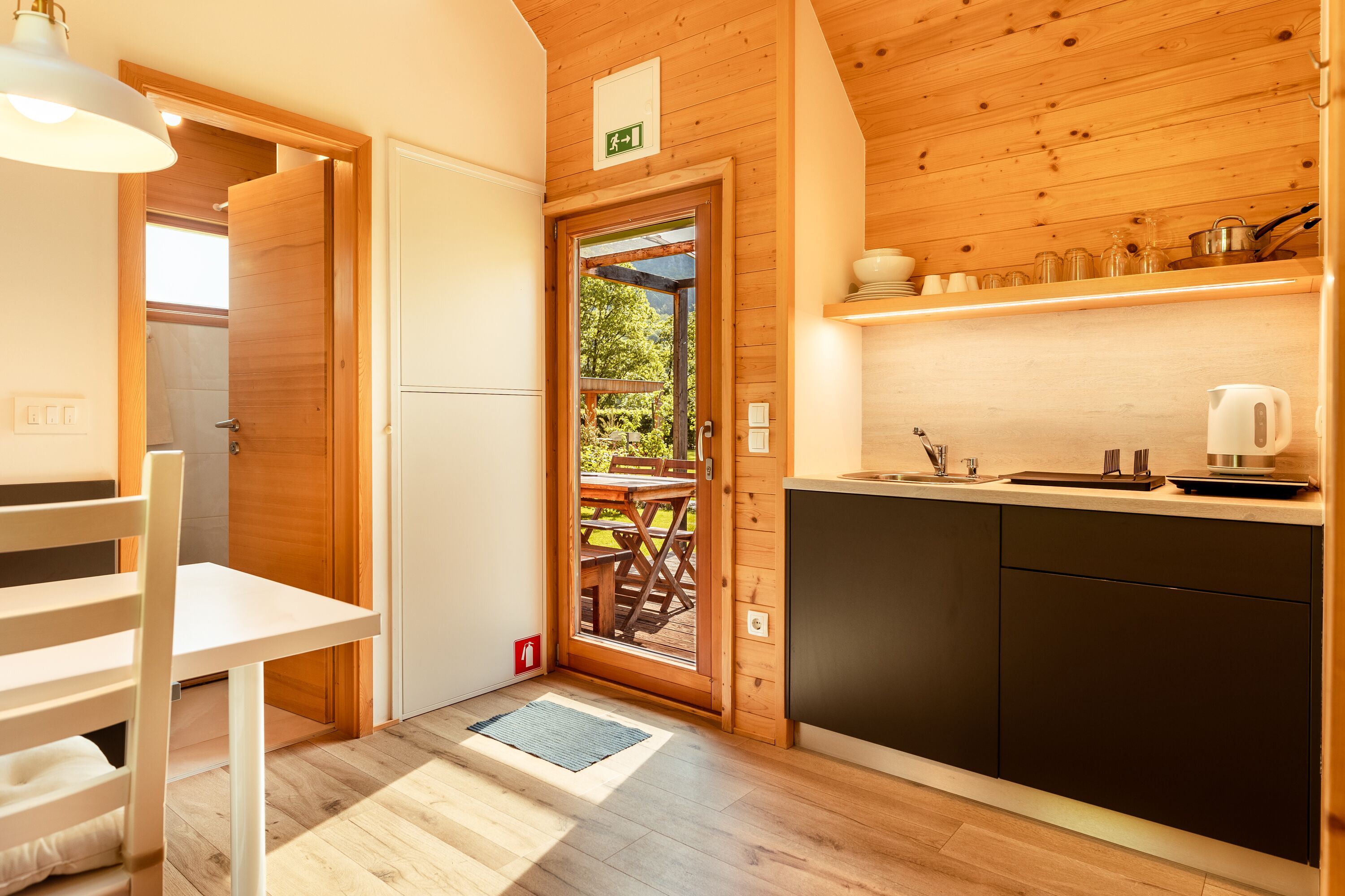 Une cuisine compacte dotée de meubles en bois, d’un évier et d’un coin repas avec une table et des chaises.