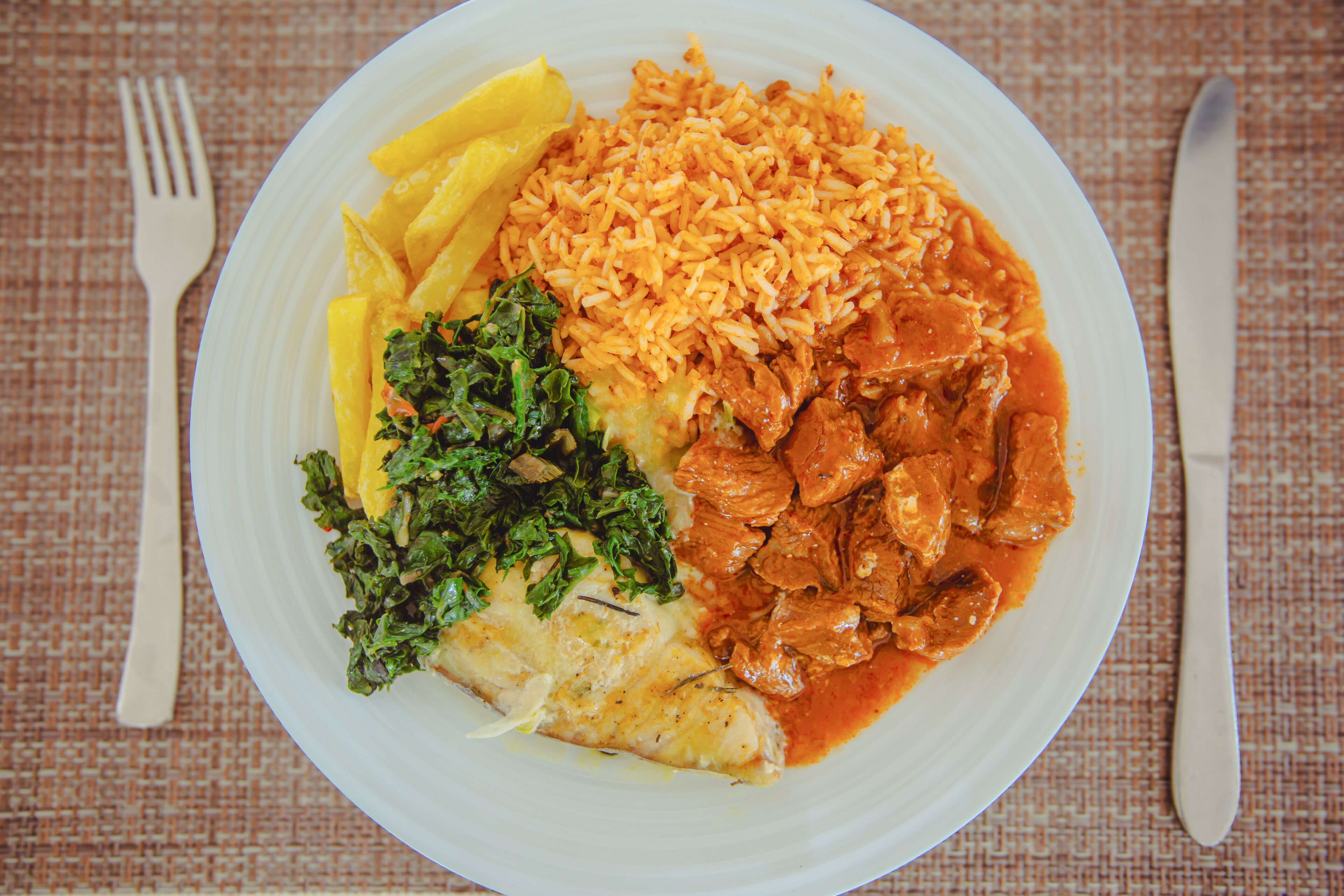 Un plato de arroz, pollo y verduras.